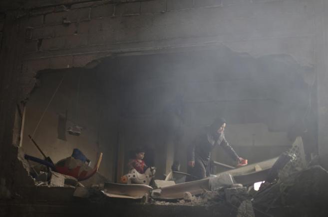 Luego de los ataques de este lunes, una mujer palestina rebusca entre los escombros de lo que antes era su casa. (Reuters)