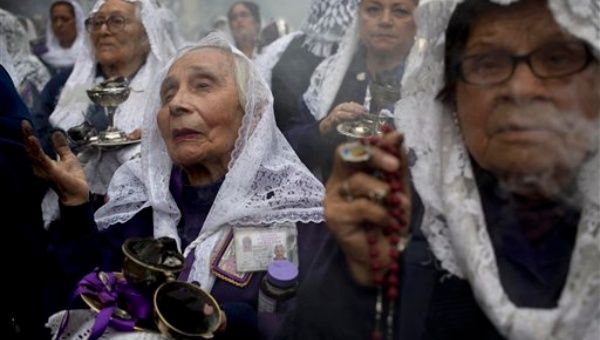 Las mujeres cubiertas con velos blancos perfuman el aire con incienso y rezaban el rosario a medida que la procesión se abre paso. (Foto: AP)