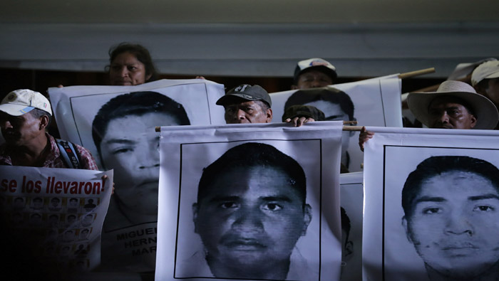 Familiares de los estudiantes desaparecidos sujetan sus fotografías durante las protestas (Foto: Reuters)