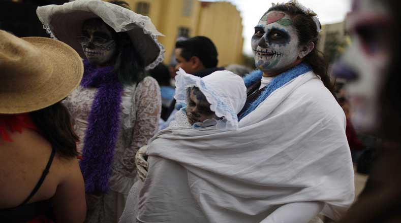 Una mujer llevó a su hijo al desfile, ambos con las caras pintadas (Foto: Reuters)