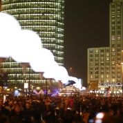 La gente camina bajo los globos iluminados que representan al Muro de Berlín en Potsdamer Platz