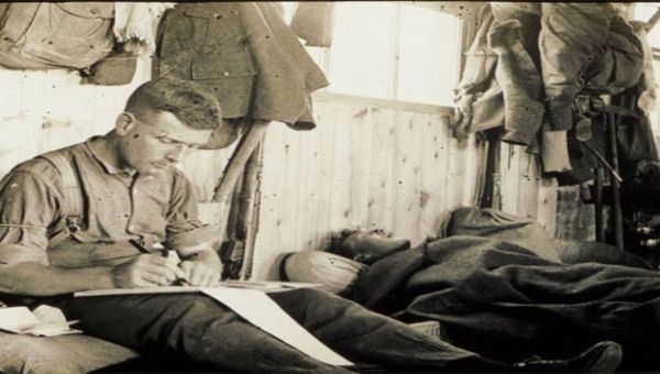 John Ewing desde Belfast (Irlanda) escribe en un diario una carta a casa, mientras que su compañero está durmiendo en su cama. Más tarde Ewing fue ascendido a sargento y ganó la Medalla Militar por su valentía en el campo.  (Foto: National Museums Northern Ireland)