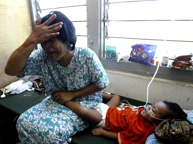 Una mujer llora junto a la cama de su hijo en un hospital de Banda Aceh, (Indonesia).