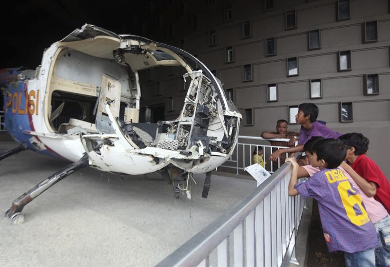 En el Museo del Tsunami en Banda Aceh (Indonesia) varios niños ven los restos de un helicóptero de la policía. 