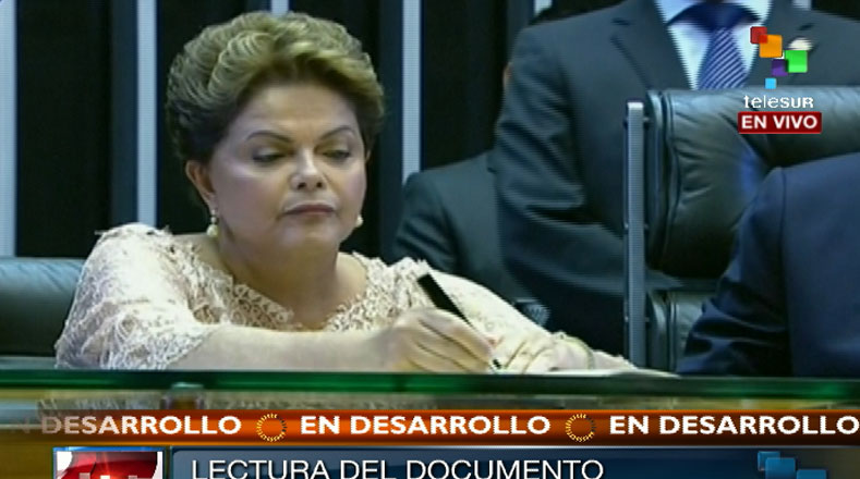 Rousseff firma el acta.