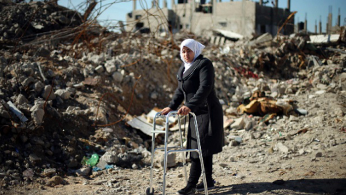 Niña Palestina de Al-Manar Shinbari, 15, quien perdió ambas piernas por lo que los médicos dijeron fue el bombardeo Israelí a una escuela de la ONU, donde ella estaba tomando refugio durante la guerra de 50 días el pasado verano, utiliza su andador cerca de las ruinas de su casa que los testigos dijeron fue destruida por los bombardeos Israelíes durante la guerra, en Beit Hanoun, en el norte de la Franja de Gaza,13 de enero 2015