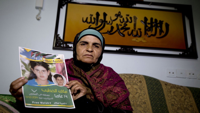 Jaula Al Jatib, sostiene un retrato de su hija Malak, de 14 años.