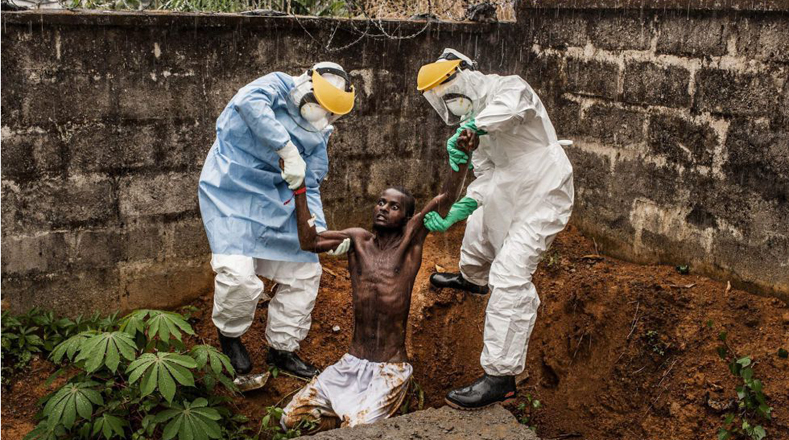 Fotógrafo: del estadounidense Peter Muller, la imagen muestra a personal sanitario en un centro de atención a enfermos de ébola con un paciente en estado de delirio en Hastings (Sierra Leona), el pasado 23 de noviembre de 2014.