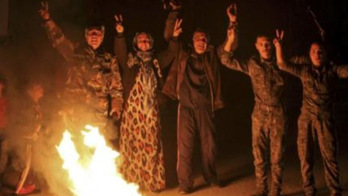 Civiles Kurdos y los combatientes de las Unidades de Protección del Pueblo Kurdo (YPG) celebran en Ras al-Ain, después se informó que las fuerzas Kurdas tomaron el control de la ciudad Siria de Kobani.