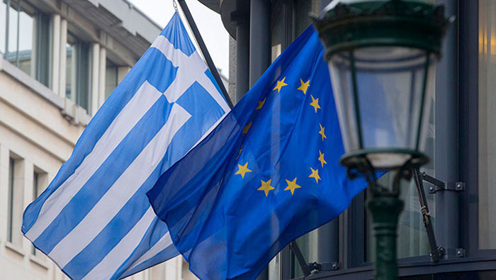 Una bandera griega (I) y una bandera europea frente a la embajada griega en Bruselas el 19 de febrero 2015