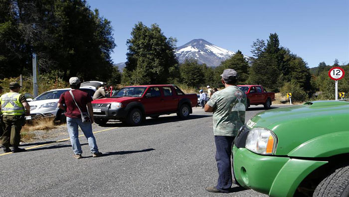 Personas esperan en carretera cerrada por la policía chilena en inmediaciones al volcán Villarrica