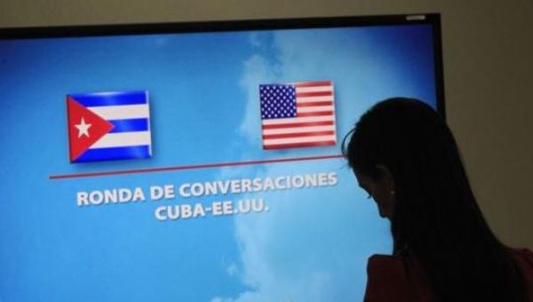 A journalist stands near a screen announcing a round of negotiations between Cuba and the U.S. in Havana, January 22, 2015.