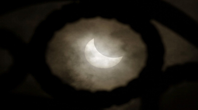El eclipse de sol fue visto con dificultad debido a las nubes desde el paseo marítimo de A Coruña, en Galicia.