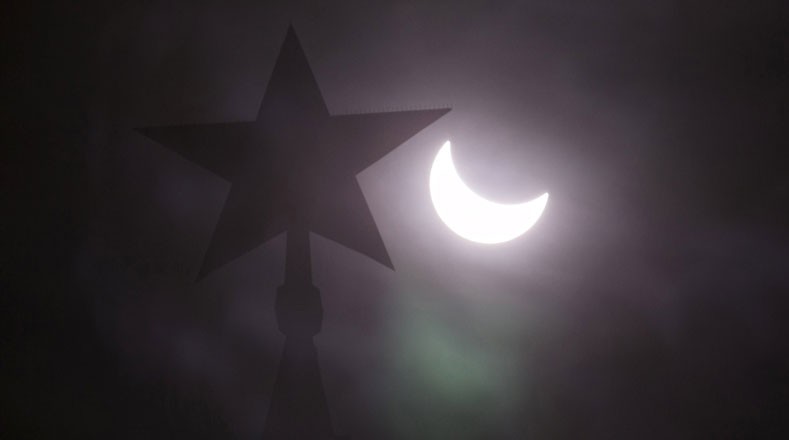 Una estrella en la parte superior de la torre del Kremlin se ve durante un eclipse solar parcial en el centro de Moscú.