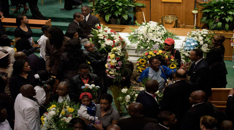 Familiares de Gray oran en una iglesia, mientras Baltimore manifiesta