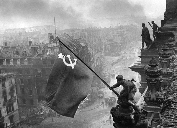 Un soldado sostiene la bandera soviética sobre el parlamento alemán en Berlín, en mayo de 1945.