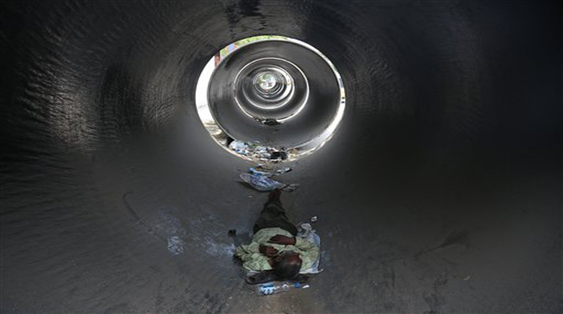 Un hombre se esconde dentro de una tubería de concreto en Hyderabad porque no aguanta el calor excesivo. 