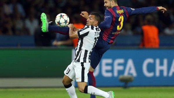 Gerard Piqué y Carlos Tevez del Juventus compiten por el balón durante el partido de fútbol final de la UEFA Champions League.