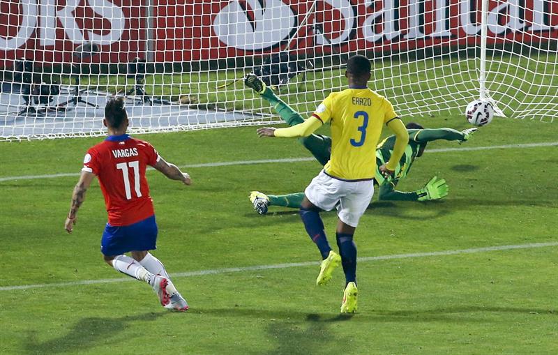 El delantero chileno Eduardo Vargas (i) bate al portero ecuatoriano Alexander Domínguez (d) para marcar el segundo gol de su equipo.