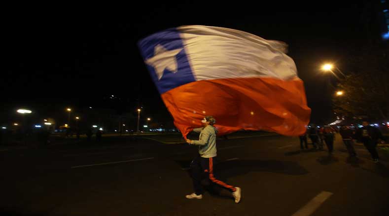 Un hincha chileno ondea la bandera nacional previo al partido inaugural ante Ecuador
