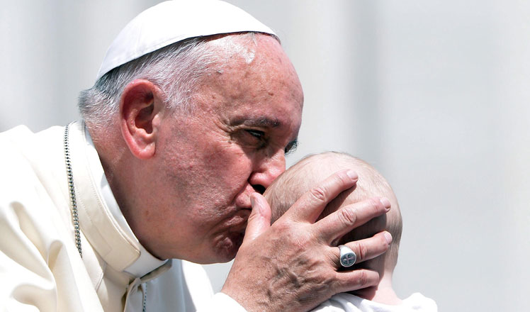 El papa Francisco besa la frente a un bebé durante la audiencia general de los miércoles celebrada en la Plaza de San Pedro.