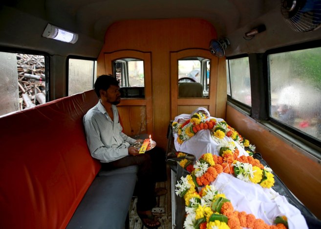 Un indio, junto al cuerpo de una de las víctimas, en una ambulancia, en Bombay.