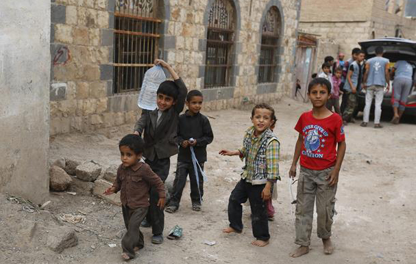 Niños yemeníes esperan por paquetes de comida entregados por voluntarios.