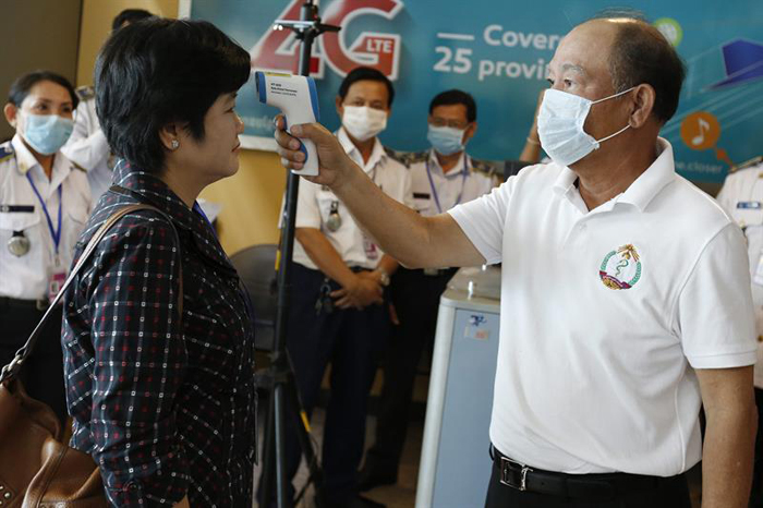 El ministro de Sanidad, Mam Bun Heng (dcha), realiza una comprobación del nuevo escáner térmico en el aeropuerto de Phnom Phen.