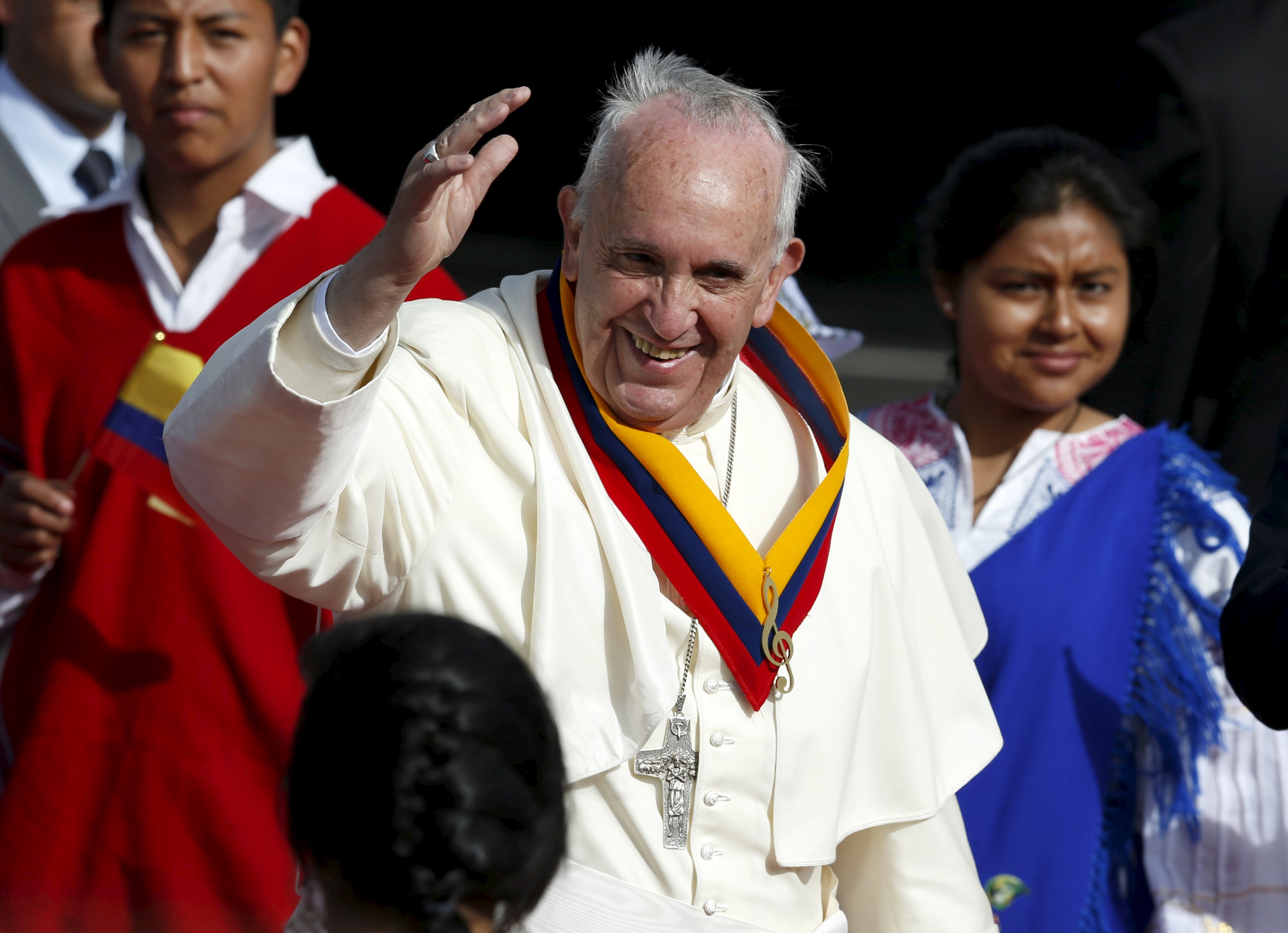 El papa Francisco saluda vistiendo una faja con los colores de Ecuador a su llegada a Quito.