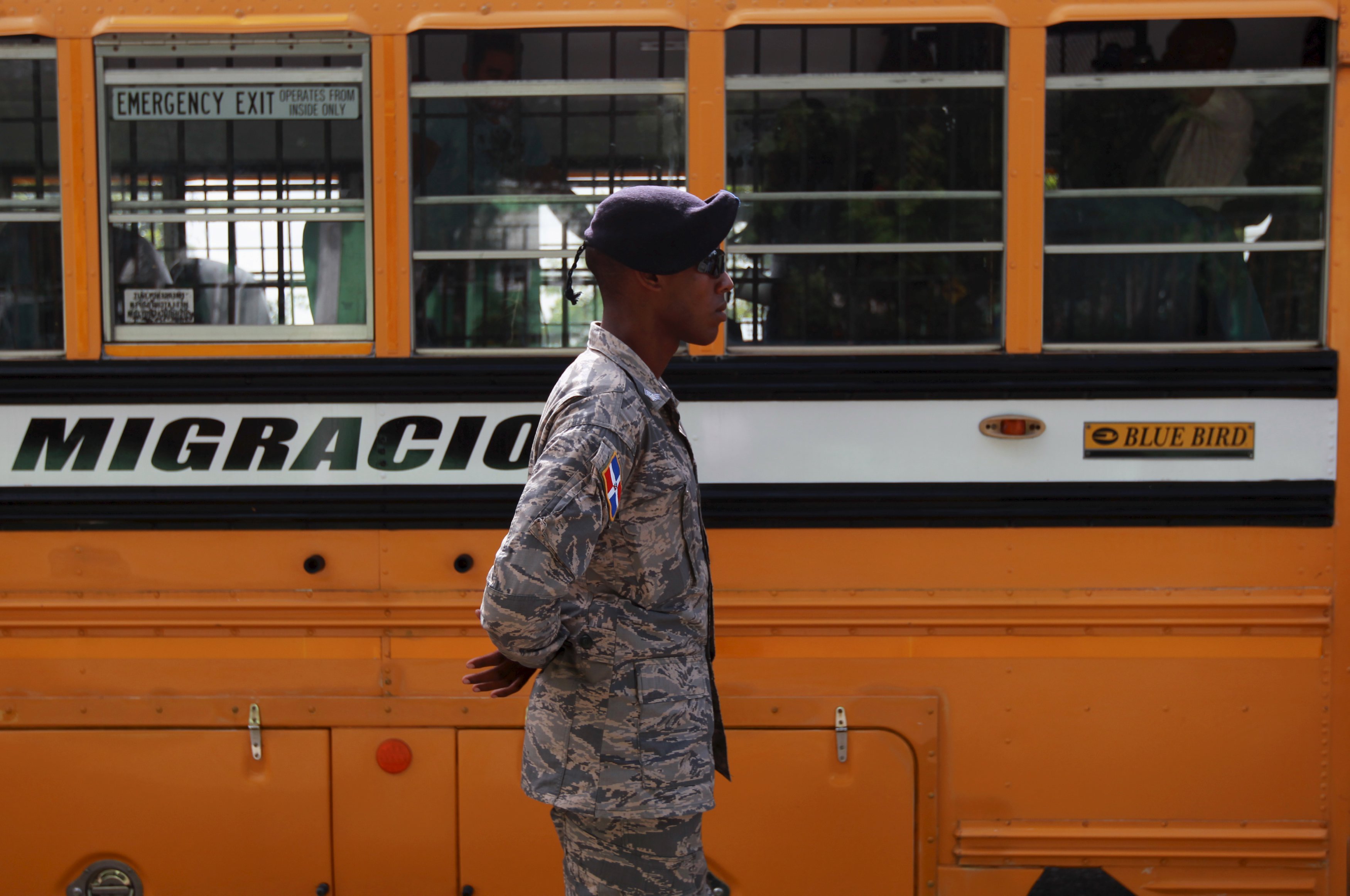 Un soldado dominicano hace guardia en uno de los autobuses de la Oficina Nacional de Migración en Santo Domingo, 24 de junio de 2015.