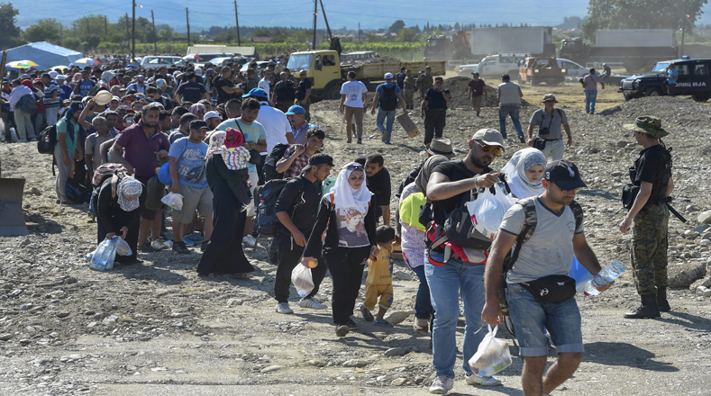 Migrantes marchan luego de recibir permiso para avanzar hacia la estación de tren en el nuevo campo de refugiados que hay en la construcción y que servirá para la aceptación y registro de los mismos.