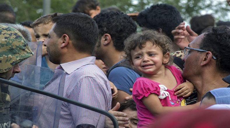Esperan a ser transportado a un centro temporal para los refugiados.