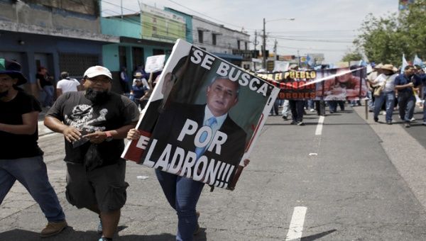 Con carteles despectivos, los guatemaltecos siguen exigiendo la renuncia del presidente, quien se niega a dimitir. 