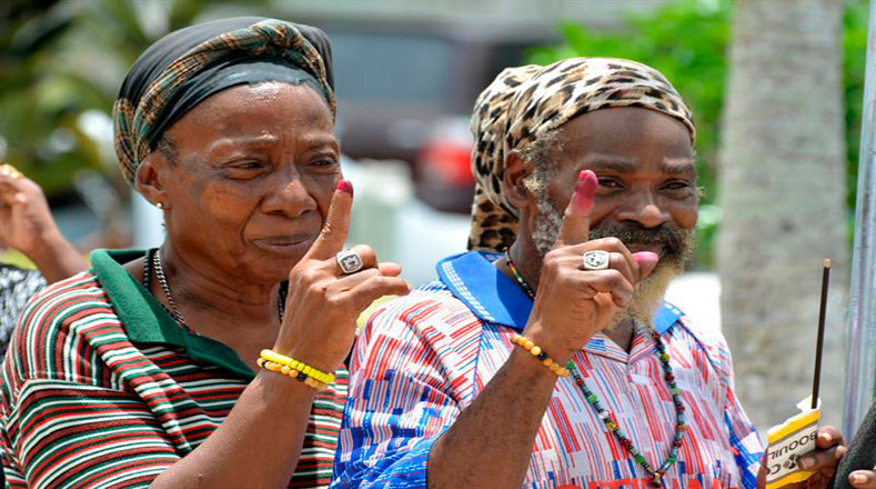 Una pareja mostró sus dedos marcados de rojo después de votar en las elecciones generales de este lunes en un centro de votación en la población de Lendore.