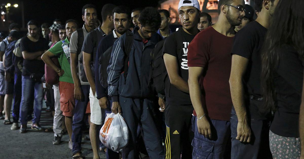 Los refugiados esperan ser trasladados por la policía griega.