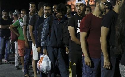 Los refugiados esperan ser trasladados por la policía griega.