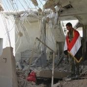 Cubierto con la bandera de su país, un soldado sirio observa las ruinas de una casa en Achan, provincia de Hama. Rusia intensificó el lunes pasado ataques contra terroristas del Estado Islámico.