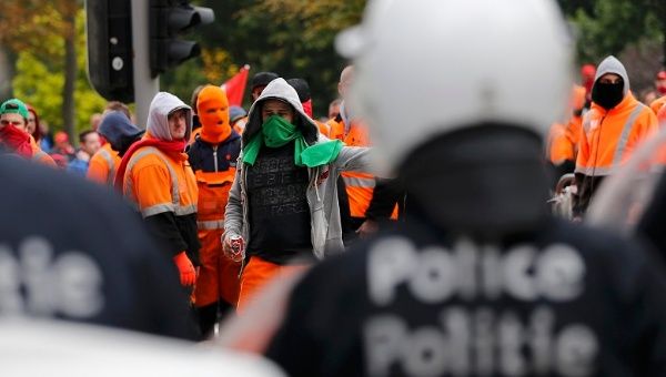 Demonstrators confront riot police in central Brussels during a protest over the government