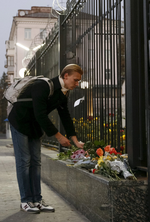 Un hombre pone flores para las víctimas de un avión ruso que se estrelló en Egipto , fuera de la embajada rusa en Kiev, Ucrania.