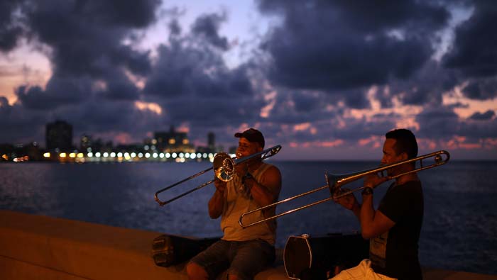 Dos músicos tocan al atardecer en el malecón de La Habana, uno de los lugares más emblemáticos de la isla.