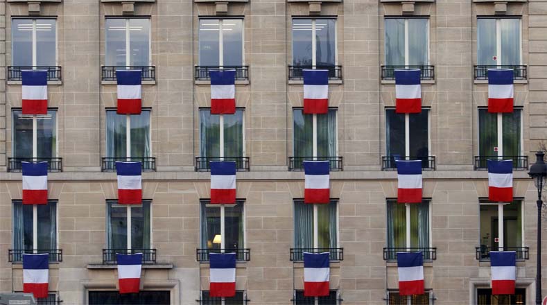 El azul, blanco y rojo de la bandera francesa se desplegó en las ventanas de un edificio cercano al palacio.