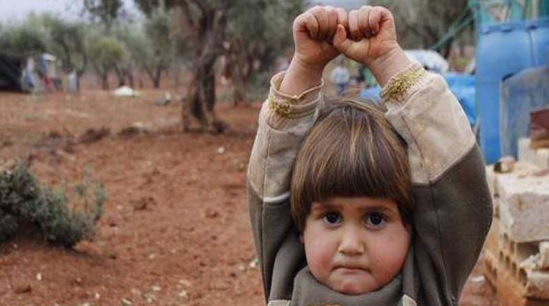 Esta imagen ha recorrido el mundo. Una supuesta niña siria perturbada por el  conflicto en su país, se rinde de manera nerviosa ante el lente fotográfico de un reportero.