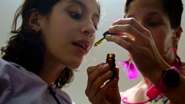 Ines Cano administers medical marijuana to her daughter Luna Valentina (L) at their home in Medellin on November 25, 2015; Valentina, 12, was born with refractory epilepsy and uses cannabis to calm her seizures.