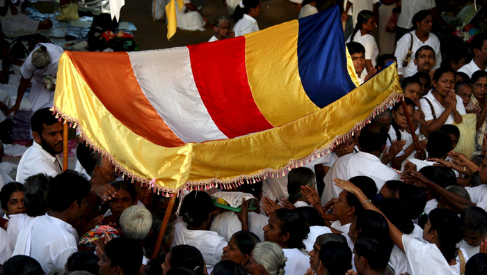 Devotos budistas de Sri Lanka llevan una ofrenda a un templo.