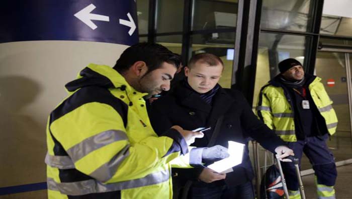 Agente de seguridad comprueba la identificación de un pasajero en la estación de tren del aeropuerto de Copenhague en Kastrup para impedir la entrada en Suecia de migrantes sin permiso de residencia.