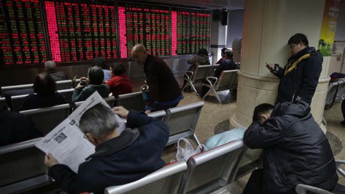 Inversores siguen la evolución de las Bolsas desde Pekín.