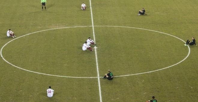 Los jugadores de ambos equipos se sentaron en el césped como señal de protesta en solidaridad con los refugiados.