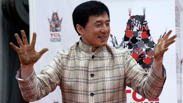 El actor chino Jackie Chan posa después de dejar sus manos en cemento en junio de 2013, el Teatro Chino TCL.