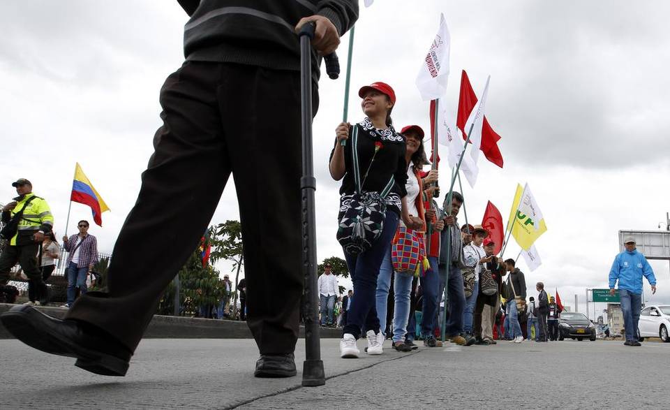 Participantes realizan una cadena humana durante una marcha contra la violencia y en memoria de los desaparecidos hoy, sábado 9 de abril de 2016, durante la conmemoración del Día Nacional de las Víctimas, en Bogotá (Colombia).