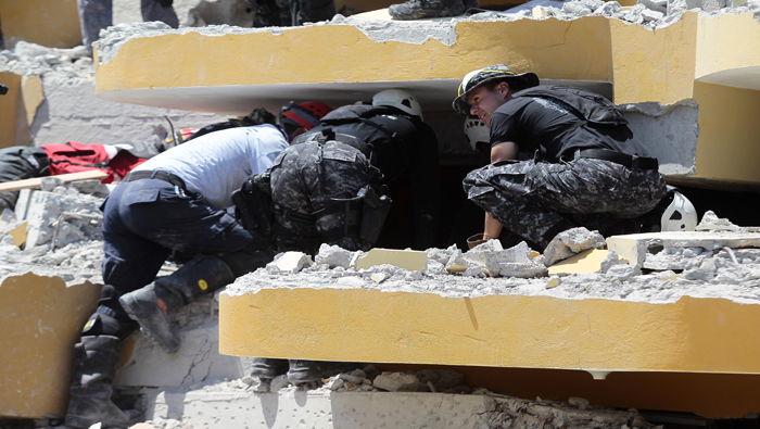 Bomberos ecuatorianos y colombianos buscan sobrevivientes entre los escombros en Pedernales (Ecuador).